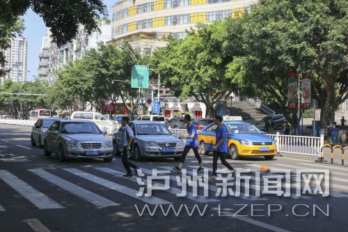 四川警察學(xué)院前的斑馬線沒有紅綠燈，但過往車輛見到有行人過斑馬線都會禮讓行人